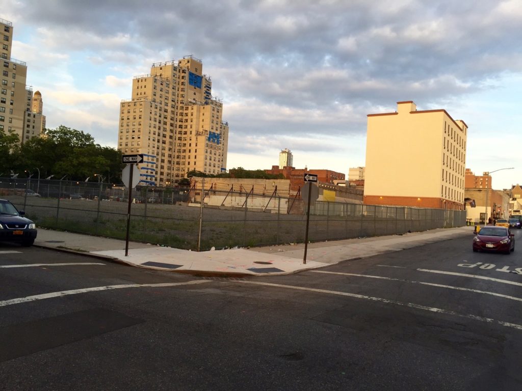 View of vacant lot with NYCHA building in background